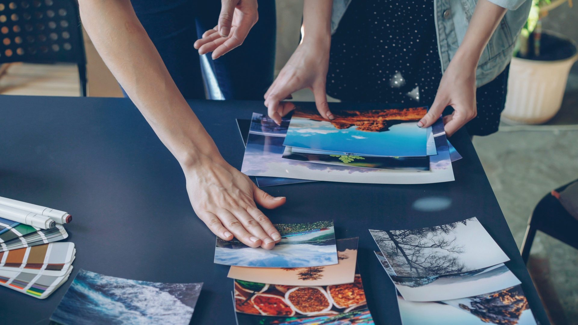 People are arranging photos on a table.